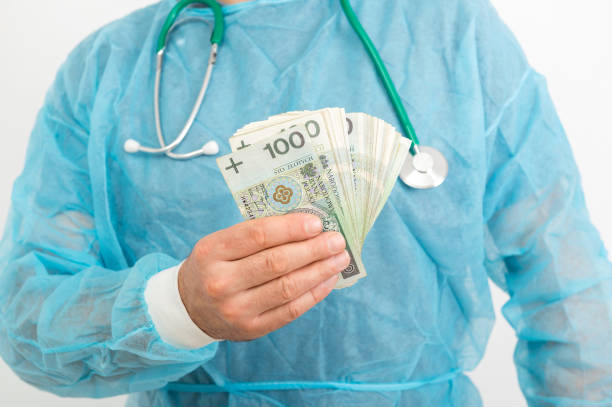 Doctor hand holding pile of Polish money banknotes. Medical services financial concept Doctor hand holding pile of Polish zloty banknotes. Medical services financial concept polish zloty photos stock pictures, royalty-free photos & images