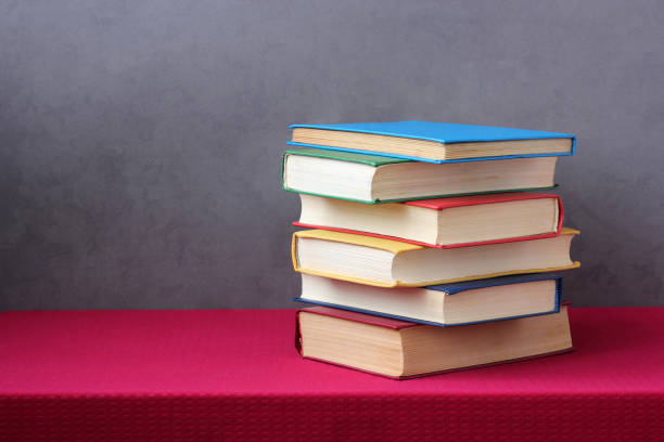 istock stack of books in colored hard covers on the table. 1197002319