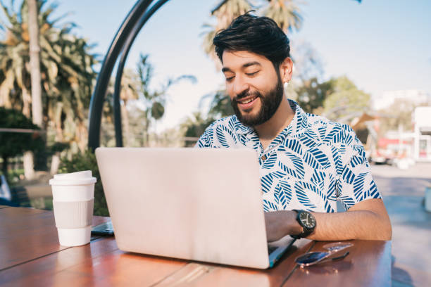 istock Young man using his laptop in a coffee shop. 1197004559