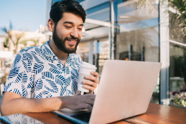 istock Young man using his laptop in a coffee shop. 1197004572