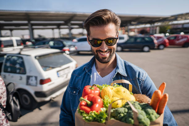 istock Vegan man holding vegetable filled bag 1197005407