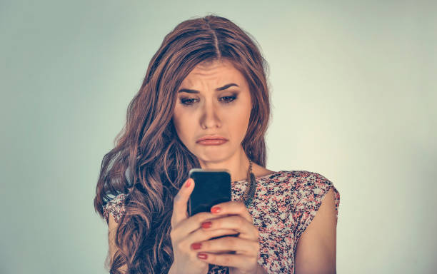 istock Woman looking at phone message very with sad expression on face 1197007304