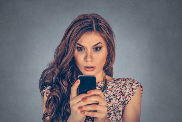 istock Woman looking at her phone with shocked expression on face 1197007330