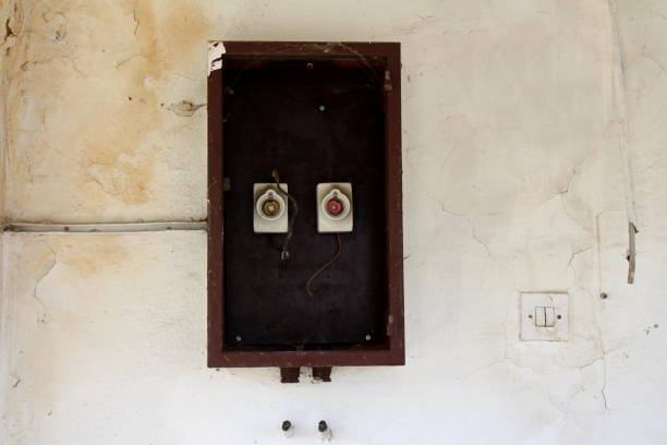 istock Two old vintage retro disconnected ceramic fuse holders with missing fuses inside wooden box on dilapidated cracked wall 1197007496