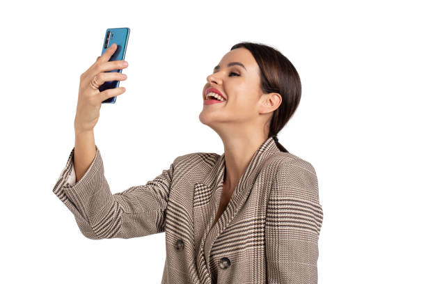 istock Expressive woman in gray chequered suit taking selfie isolated on white 1197009245