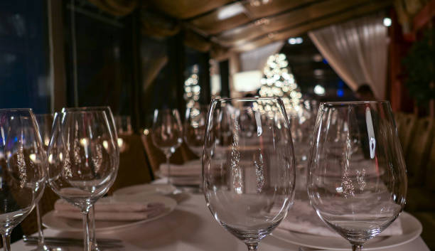 istock New year service in restaurant with transparent glasses, illuminated evergreen tree, multiple reflections and defocused background 1197009339