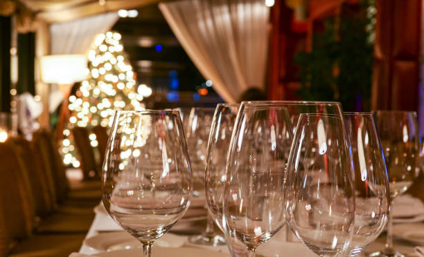 istock New year service in restaurant with transparent glasses, illuminated evergreen tree, multiple reflections and defocused background 1197009387