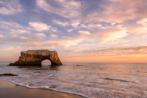 Sunset view of the Natural Bridges mudstone formation that is carved by the Pacific Ocean into cliffs that jutted out into the sea.

Taken in Santa Cruz, California, USA
