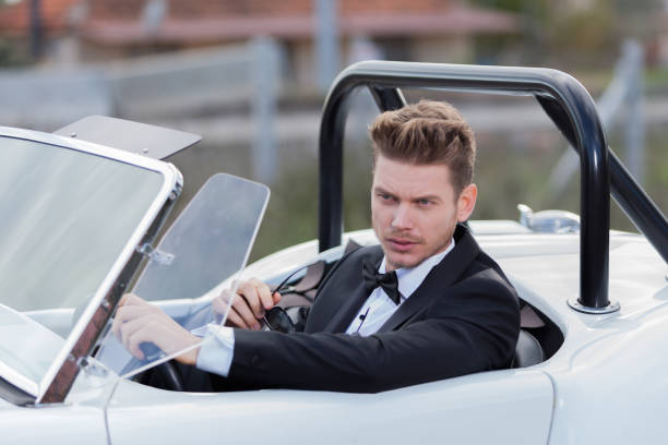 istock Handsome man driving a vintage car 1197012757