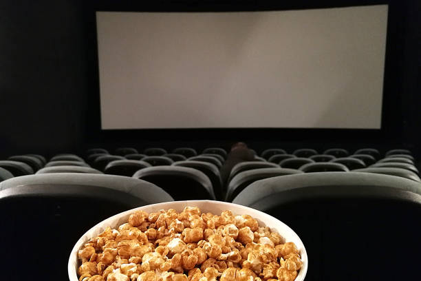 istock Cinema seat and pop corn facing empty movie screen 1197017037