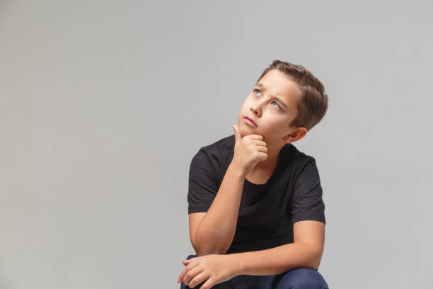 istock Ten- years boy looking up, daydream. Isolated on the gray background 1197017152
