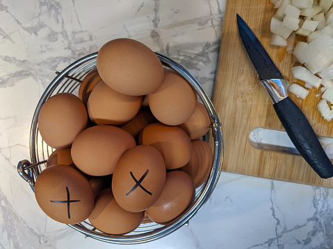 X Marked on Brown Egg with a Black Marker Indicating Oldest Ones to Use First