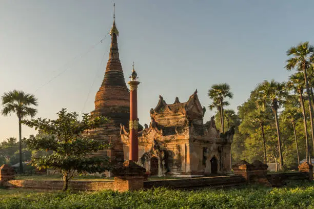 A small temple complex with typical buddhist stupas located in Hanthawaddy at the Inwa areal nearby Mandalay during sunset