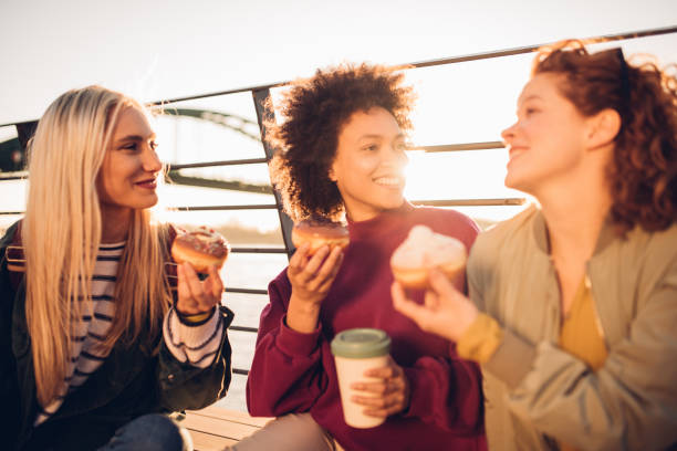 istock Three friends enjoying donuts together 1197022412