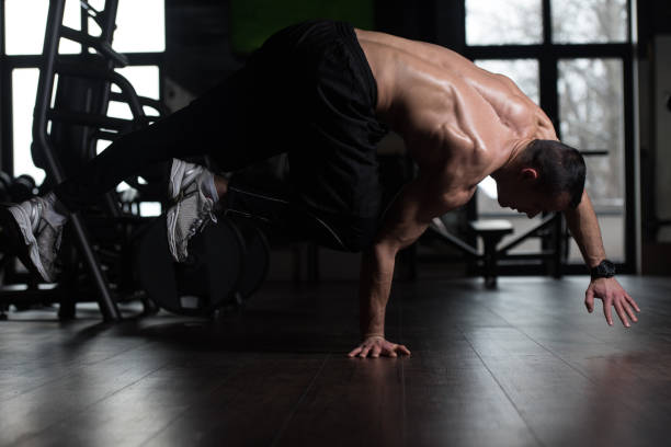 istock Man Doing Extreme Handstand In Gym 1197022507