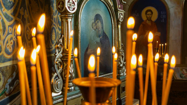 verschwommenes wachs brennende kerzen in einer orthodoxen kirche auf dem symbolhintergrund. - orthodoxes christentum stock-fotos und bilder