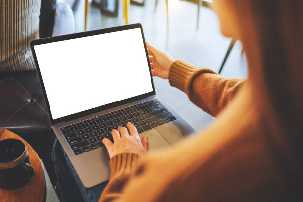 a woman using and typing on laptop computer with blank white desktop screen