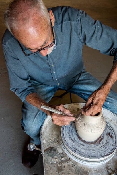 istock senior man working on a pottery wheel making clay pots. 1197045443