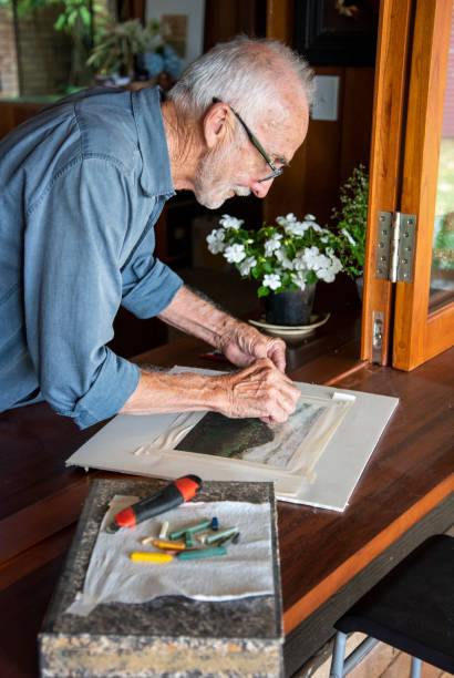 istock senior male working on his pastel drawing in an open window. 1197047169