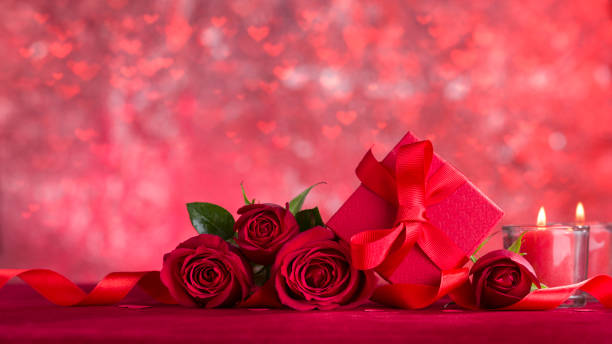 istock Roses and red gift wrap on red velvet fabric 1197048346