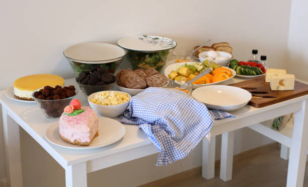 istock Brunch at Home - Serving Table with Cheese, Fruit, Salads, Eggs, Breads, Cakes, Cookies and More 1197059006