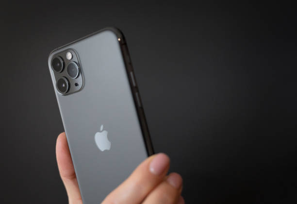 person holding apple iphone 11 pro on dark background - xi imagens e fotografias de stock