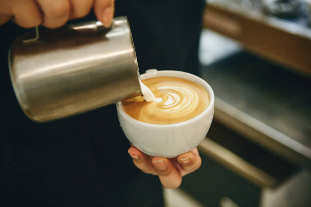 istock Barista pours milk into coffee 1197063412