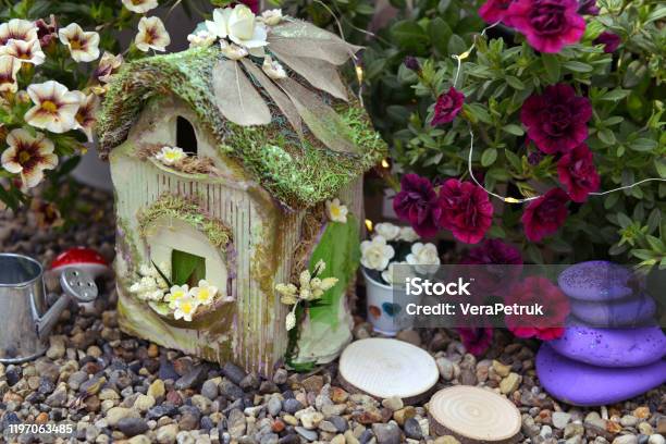 Small Fairy Cottage With Petunia Flowers Outside In The Garden Stock Photo - Download Image Now