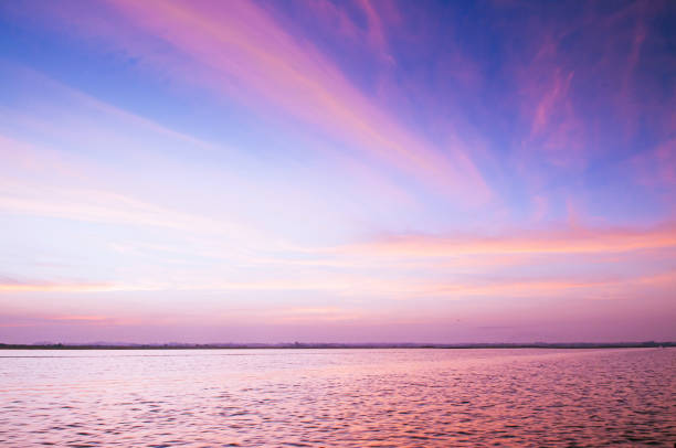 Beautiful burning dramatic sunrise or sunset sky over wide peaceful Nong Harn lake, Udonthani - Thailand.