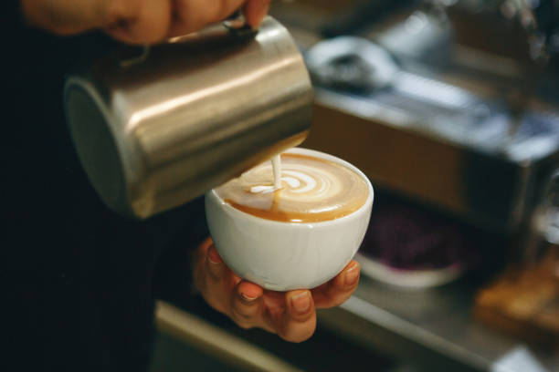 istock Barista pours milk into coffee 1197064221