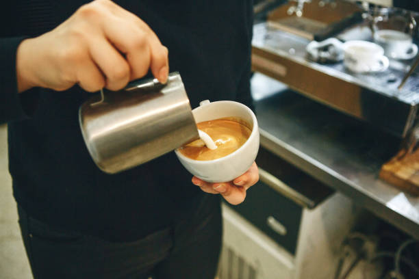 istock Barista pours milk into coffee 1197064252