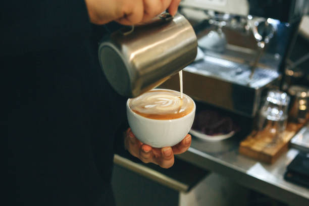 istock Barista pours milk into coffee 1197064289