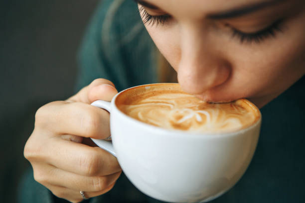 fermez-vous vers le haut de la fille boit le café - coffee cup cappuccino food photos et images de collection