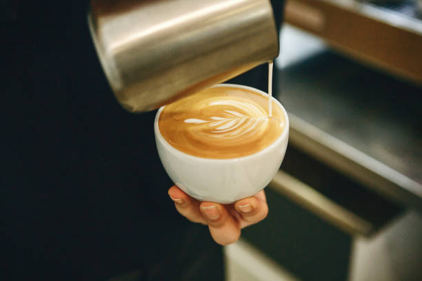 istock Barista pours milk into coffee 1197065112