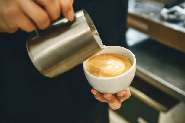 istock Barista pours milk into coffee 1197065137