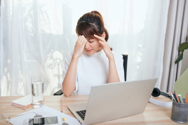 istock Young Asian woman feeling tired at her office 1197066480