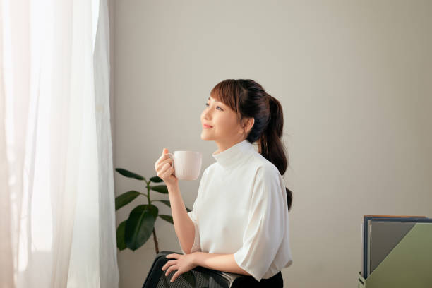 istock beautiful young Asian woman drinking coffee 1197067135