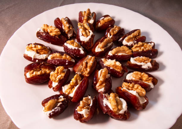 istock Fresh dates filled with mascarpone cheese and walnuts in a white dish. 1197067204