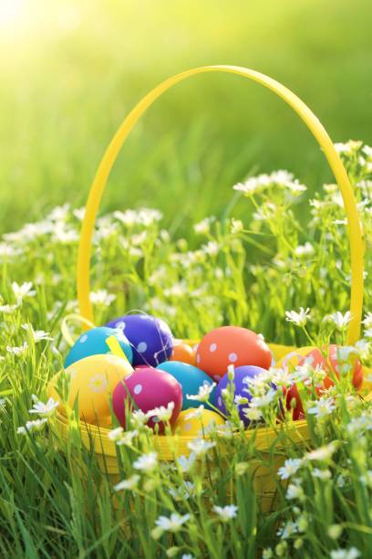 istock Easter time. Multi-colored Easter eggs decor in a yellow basket on a flowering spring meadow in bright sunshine.Bright easter colorful background.Spring Religious April Holiday. 1197069780