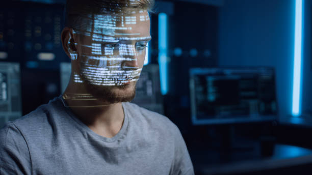 Handsome Young Software Developer Working on Personal Computer in Digital Identity Cyber Security Data Center, Program Coding Language Reflects on His Face. Futuristic Hacking and Programming Concept guapo joven desarrollador de software que trabaja en computadora personal en el centro de datos de seguridad cibernética de identidad digital, el lenguaje de codificación de programas se refleja en su cara. concepto futurista de hackeo y programación
