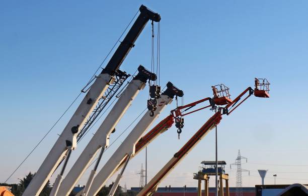 istock Mobile crane booms and work aerial platforms lined up in an industrial development area 1197074162