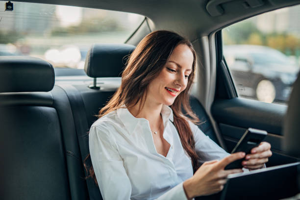 istock Businesswoman using smart phone in a car 1197075126