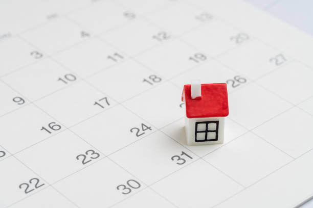 Housing, property or real estate or mortgage payment concept, miniature house with red roof on the end of month 31th date white clean calendar stock photo