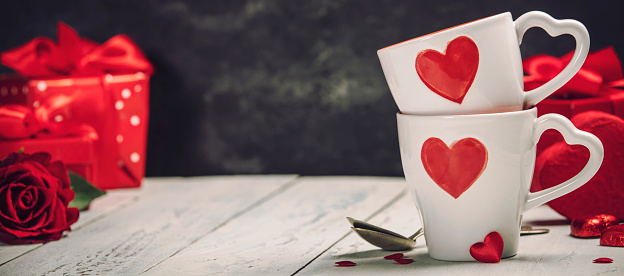 Valentine's Day concept. Red Cups, gift boxes and roses on a Wooden Background. Love or Valentine's Day Concept.