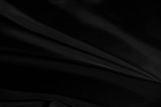 istock Black gray satin dark fabric texture luxurious shiny that is abstract silk cloth background with patterns soft waves blur beautiful. 1197079350