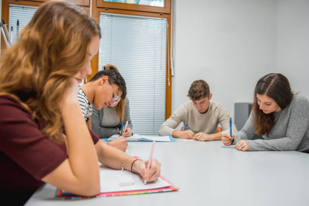 istock Two friends using smart phone and smiling in the classroom 1197080338