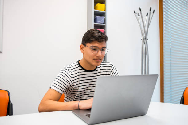 istock Hispanic teenange boy using laptop in the classroom 1197080576