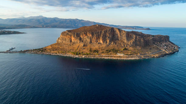 Monemvasia, small rocky peninsula next to Peloponnese with small settlement in Greece. Aerial view made with drone before sunset, with soft sunlight