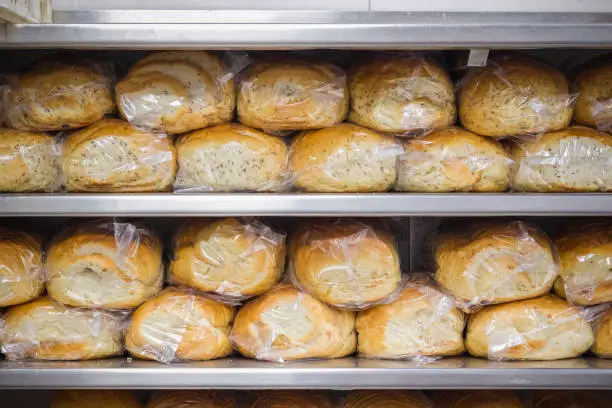 Many loaves of breads displayed on shelves at Brick Lane bakery Beigel Bake in London