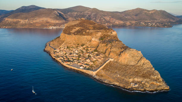 Monemvasia on Peloponnese, Greece Monemvasia, small rocky peninsula next to Peloponnese with small settlement. Located in Greece. Aerial view made with drone at morning, with soft sunlight monemvasia stock pictures, royalty-free photos & images